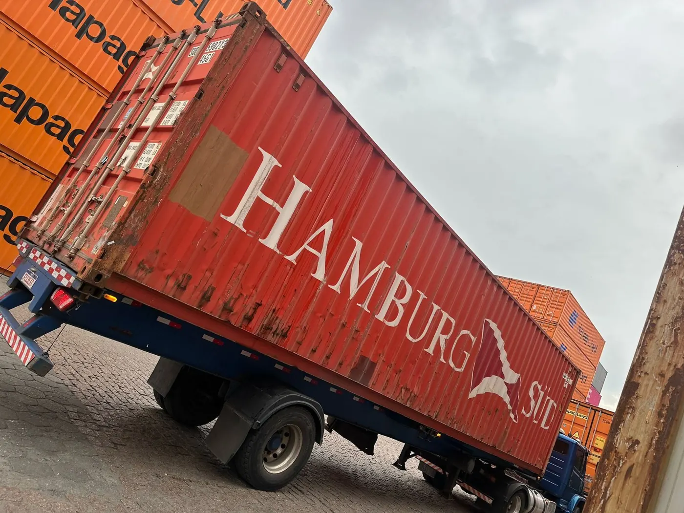 Container sendo carregado em caminhão para entrega
